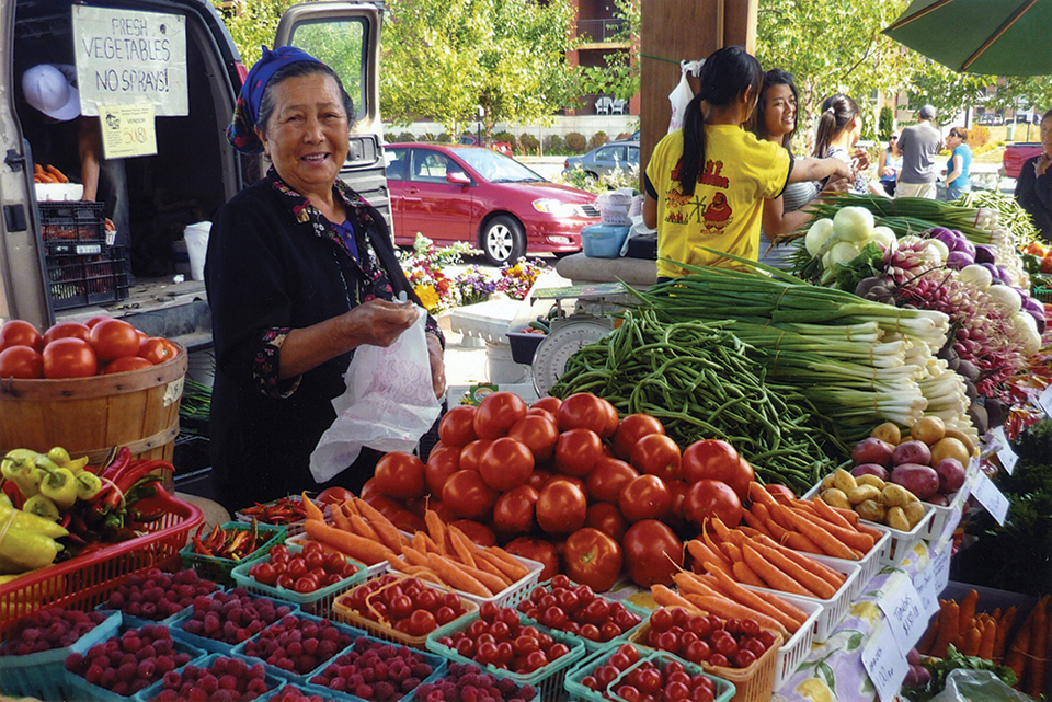 Nplias Yaj, a farmer, sells vegetables at the Eau Claire Downtown Farmers Market