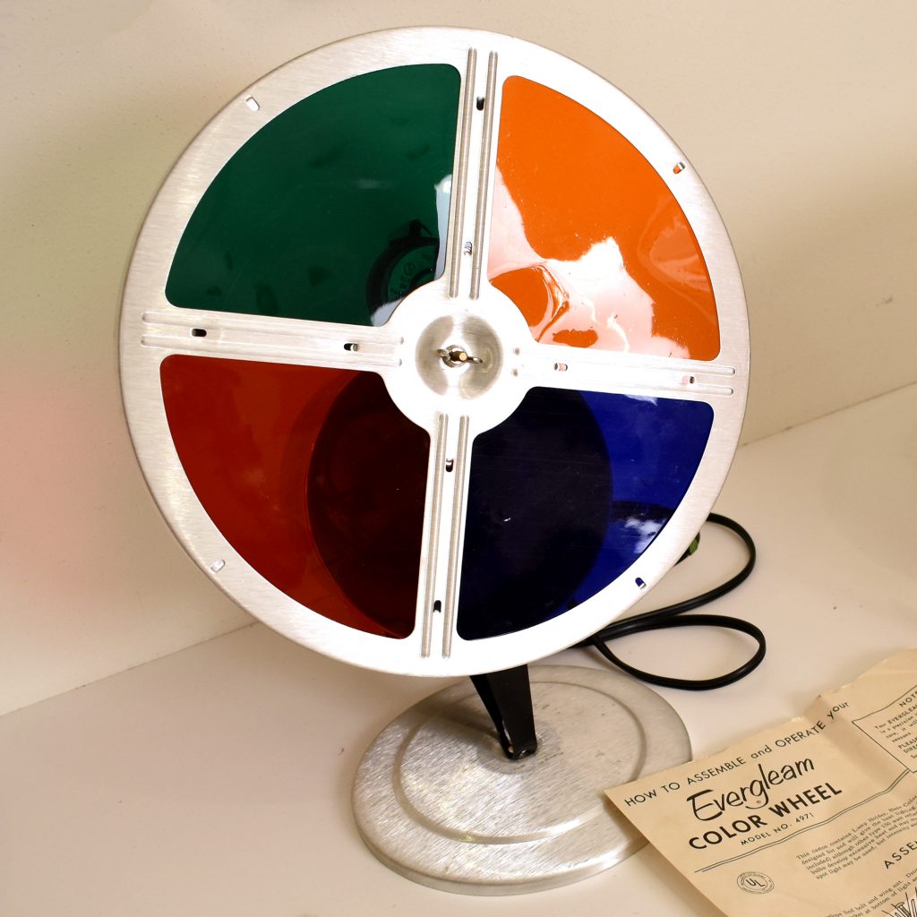 Evergleam Motorized Color Wheel, early to mid-1960s. This fixture contains both a light bulb and a small motor to spin the color wheel. When the wheel is placed on the floor and pointed upward at an Evergleam, the shiny branches reflect swirling colored light. (Private collection)